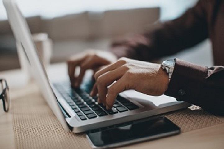 person typing on laptop image